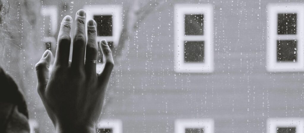 mano sobre ventana con lluvia blog isfap